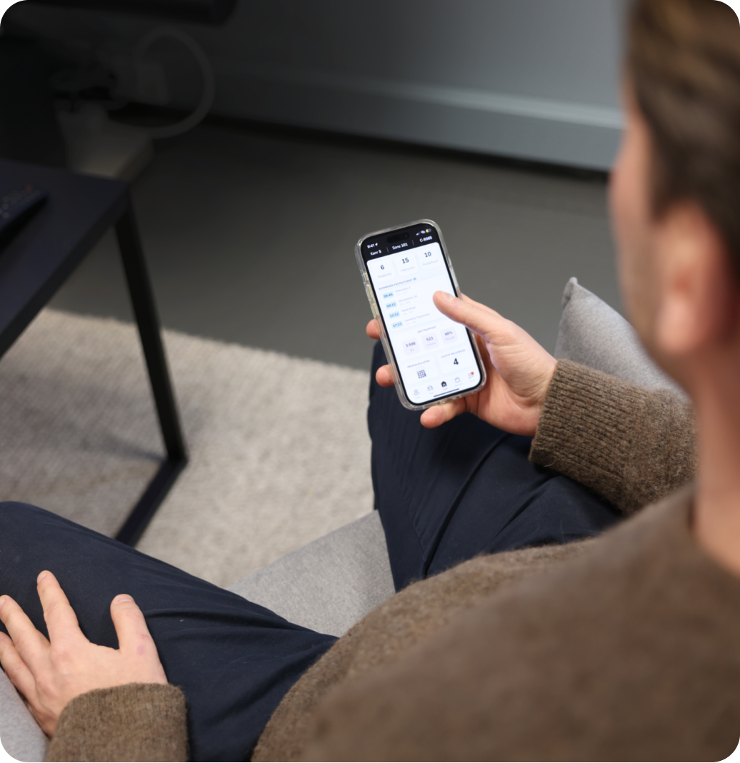 Mann som sitter med telefon i hånda